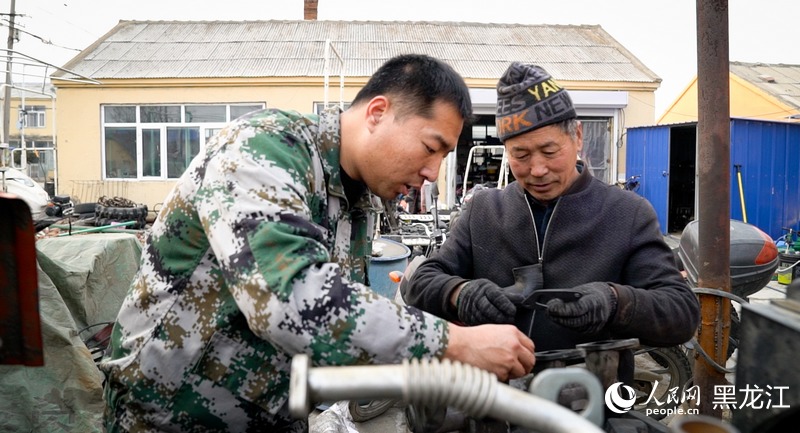 备春耕期间，杨庆宝帮助村民检修拖拉机。人民网记者 苏靖刚摄