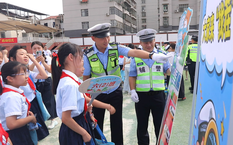 闯关集章区,同学们在现场民警引导下学习交通安全知识。