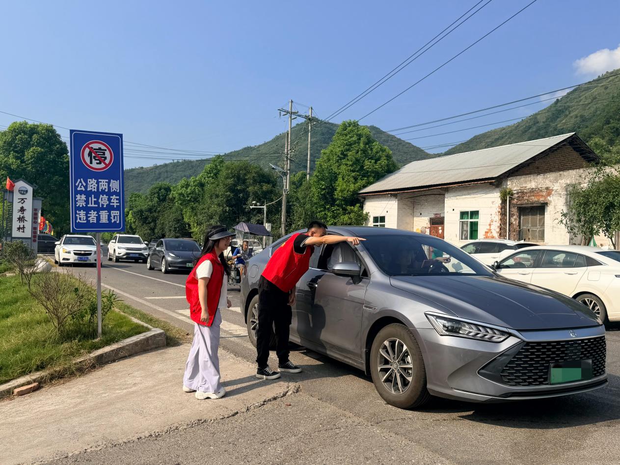 咸安烟草志愿者引导游客到新建停车场规范停车。