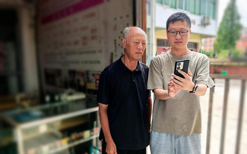 客户经理金文健指导店主在手机上操作终端系统