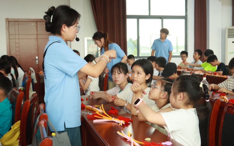 李佳颖左一辅导孩子制作非遗手工制品。